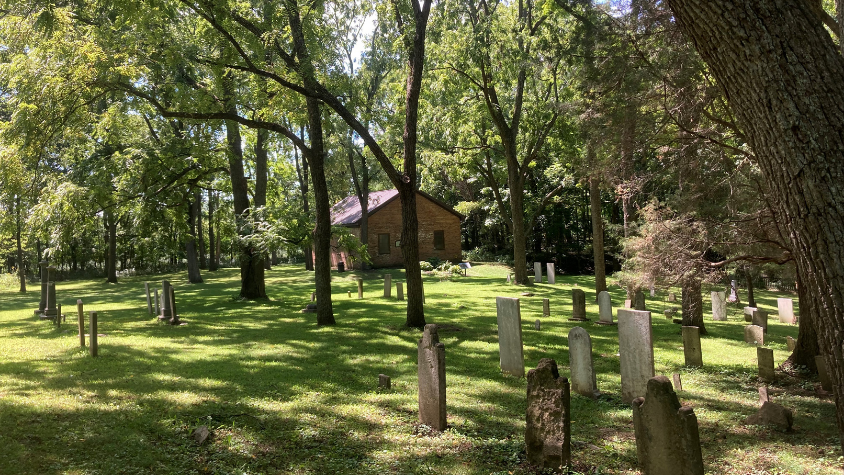 Historic brick church and headstones in a cemetery